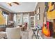 Inviting living room with guitars, keyboard and comfortable seating, flooded with natural light at 12163 Se 176Th Loop, Summerfield, FL 34491