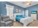 This bedroom has a chair, closet, blue accent wall, carpet, and large windows at 12163 Se 176Th Loop, Summerfield, FL 34491