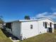 Rear view of a white single-wide manufactured home, showing the back patio and AC unit at 128 Lake Hazel Dr, Winter Haven, FL 33884