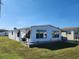 Side view of a white single-wide manufactured home with a landscaped yard at 128 Lake Hazel Dr, Winter Haven, FL 33884