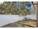 Small backyard with white fence, garden, and mature trees at 1313 Vine St, Leesburg, FL 34748