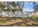 Home's fenced backyard with green grass and trees at 1313 Vine St, Leesburg, FL 34748