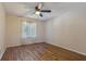 Simple bedroom with wood-look floors and ceiling fan at 1313 Vine St, Leesburg, FL 34748