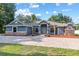 Attractive home featuring lush landscaping, a brick driveway, and charming architectural details at 13819 Sw 109Th Ln, Dunnellon, FL 34432