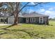 Charming one story home featuring a two-car garage and a well-manicured lawn with a large shade tree at 1511 Moss Ave, Leesburg, FL 34748