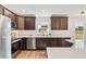 Well-lit kitchen with stainless steel appliances, white countertops and backyard view at 1511 Moss Ave, Leesburg, FL 34748