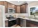 Cozy kitchen featuring stainless appliances, including a microwave and oven, and a view from the window at 1511 Moss Ave, Leesburg, FL 34748