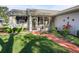 Front entry with walkway, screened porch, and landscaping at 1711 Lilly Ln, The Villages, FL 32159