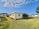 Side view of yellow single story home with landscaping and yard at 180 Hibiscus Way, Leesburg, FL 34748