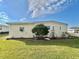 Side view of yellow single story home with landscaping and yard at 180 Hibiscus Way, Leesburg, FL 34748