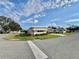 Side view of a yellow single story home with a well manicured lawn at 180 Hibiscus Way, Leesburg, FL 34748