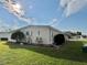 Side view of yellow single story home with landscaping and yard at 180 Hibiscus Way, Leesburg, FL 34748