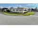 Side view of a yellow single story home with a well manicured lawn at 180 Hibiscus Way, Leesburg, FL 34748