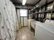 Laundry room with washer, dryer, and shelving at 180 Hibiscus Way, Leesburg, FL 34748