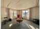 Living room with large windows, red armchair, and a coffee table at 180 Hibiscus Way, Leesburg, FL 34748