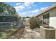 View of the backyard and side yard featuring a screened pool and an AC unit at 24450 Ne 127Th St, Salt Springs, FL 32134