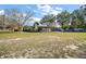 A large, green backyard provides a tranquil outdoor space with screened in porch and mature trees for shade at 24450 Ne 127Th St, Salt Springs, FL 32134