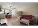 Cozy living room with a ceiling fan, modern flooring, and a comfortable burgundy sofa at 24450 Ne 127Th St, Salt Springs, FL 32134