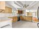 Spacious kitchen featuring wood cabinets, tile countertops, and a view into the adjoining dining area at 2450 Topping Pl, Eustis, FL 32726