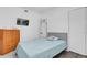 Bedroom featuring gray floors, white walls, bed with blue bedding, and a wooden dresser at 2667 Northland Rd, Mount Dora, FL 32757