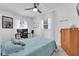 Bedroom featuring gray floors, white walls, bed with blue bedding, and a wooden dresser at 2667 Northland Rd, Mount Dora, FL 32757