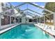 A screened-in pool with clear water, ladder, and view of backyard trees at 2667 Northland Rd, Mount Dora, FL 32757