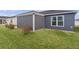 Exterior view of the backyard featuring a covered screened lanai and green lawn at 284 Pelchat Pl, The Villages, FL 32163