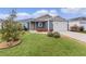 Inviting home with a lush lawn, colorful bushes, and an attached two-car garage at 284 Pelchat Pl, The Villages, FL 32163