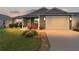 Charming single-story home featuring a well-manicured lawn and attached garage at dusk at 284 Pelchat Pl, The Villages, FL 32163