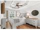 Bright bedroom featuring a comfy bed, hardwood floors, and a ceiling fan at 2987 Schoenacher St, The Villages, FL 32163