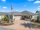 One-story home with gray roof, red flowers, and a paved driveway at 2987 Schoenacher St, The Villages, FL 32163