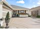 One-story home with gray roof, red flowers, and paved driveway at 2987 Schoenacher St, The Villages, FL 32163