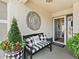 Front entry with bench, wall decor, and potted plants at 2987 Schoenacher St, The Villages, FL 32163