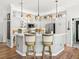 White kitchen with stainless steel appliances and patterned tile backsplash at 2987 Schoenacher St, The Villages, FL 32163