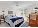 Bright bedroom with white walls, ceiling fan, and large window at 3001 Saint Thomas Ln, The Villages, FL 32162