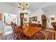 Spacious dining room with a long wooden table, chandelier, and doorway to another room at 3001 Saint Thomas Ln, The Villages, FL 32162