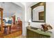 Inviting entryway featuring a green accent cabinet, mirror, and doorway leading to a spacious living area at 3001 Saint Thomas Ln, The Villages, FL 32162