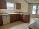 A kitchen featuring wood cabinetry, neutral countertops, and a white dishwasher at 3001 Saint Thomas Ln, The Villages, FL 32162