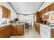 Bright kitchen with wood cabinets, a white range, and a breakfast nook area at 3001 Saint Thomas Ln, The Villages, FL 32162