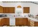 Bright kitchen featuring wood cabinets, white appliances, and a window over the sink at 3001 Saint Thomas Ln, The Villages, FL 32162