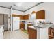 Functional kitchen with white appliances, wood cabinets, and tile flooring at 3001 Saint Thomas Ln, The Villages, FL 32162