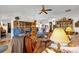Cozy living room with vaulted ceilings, plush armchairs, wooden shelving, and a patterned rug at 3001 Saint Thomas Ln, The Villages, FL 32162
