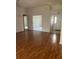 Open-concept living area with hardwood floors and multiple entryways at 3001 Saint Thomas Ln, The Villages, FL 32162