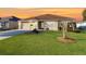 Single-story house with a beige exterior, brown roof, and landscaped lawn at 3180 Dressendorfer Dr, The Villages, FL 32163