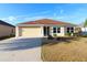 Single-story house with light-yellow walls and a brown tile roof at 3180 Dressendorfer Dr, The Villages, FL 32163