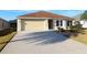 House exterior featuring a light-yellow painted exterior, attached garage, and driveway at 3180 Dressendorfer Dr, The Villages, FL 32163