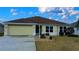 Front view of house with attached garage and landscaping at 3180 Dressendorfer Dr, The Villages, FL 32163