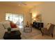 Living room with a beige couch, glass-top coffee table, and sliding doors to patio at 3180 Dressendorfer Dr, The Villages, FL 32163