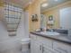 Bright bathroom with a white vanity, framed mirror and bath tub with shower featuring tiled walls at 320 Rhapsody Path, The Villages, FL 32162