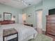 Bedroom with a large dresser, wood floors, and access to other rooms at 320 Rhapsody Path, The Villages, FL 32162